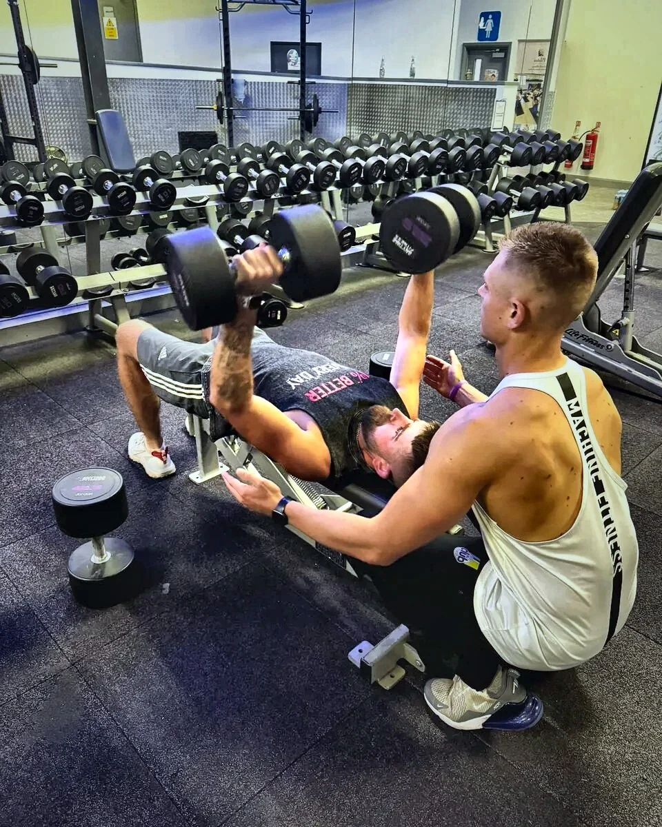 Personal trainer coaching correct lifting technique